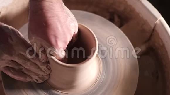 人们在陶轮上做锅的俯视图波特用专业工具塑造粘土制品花瓶或杯子视频的预览图