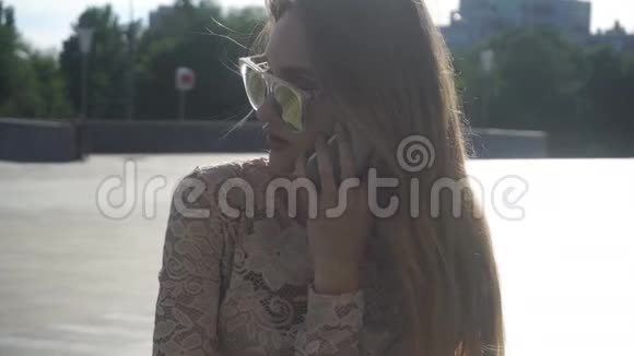 戴墨镜的金发美女在用手机说话视频的预览图