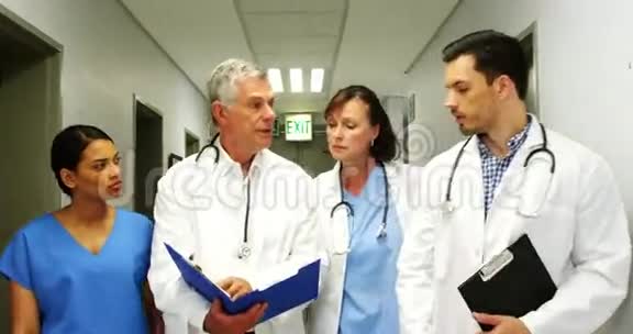 医生和护士在走廊散步时讨论医疗报告视频的预览图