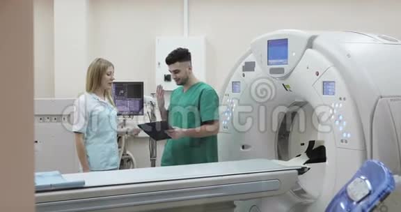 4K杨医生和护士讨论诊断的背景下一个新的磁共振成像视频的预览图