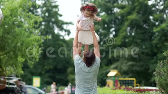 爸爸和女儿在公园里玩得很开心父亲把女孩扔了上去家庭周末父亲爱视频的预览图