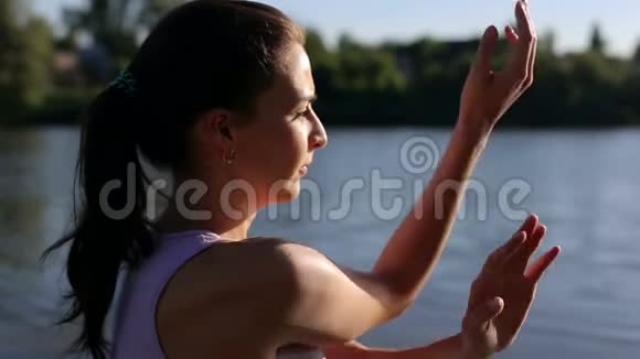 美丽的女人在大自然中练习瑜伽特写视频的预览图