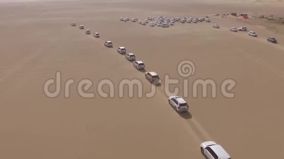 汽车穿过沙漠库存4x4越野车带游客在沙漠沙丘上的鸟瞰图视频的预览图