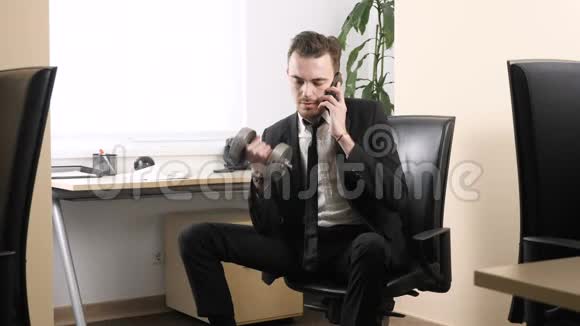 在办公室里工作穿西装的人在办公室里坐着在办公室里讲话时锻炼肱二头肌视频的预览图