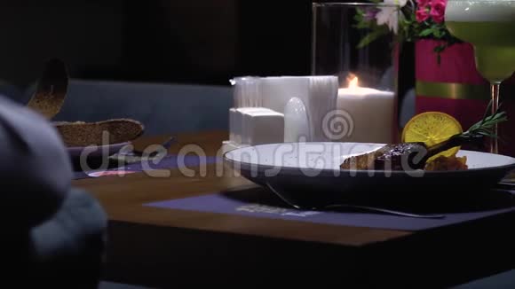 带有蜡烛的浪漫餐桌上有一道柠檬肉菜视频的预览图