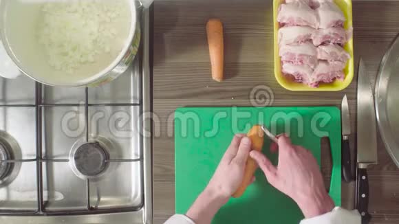厨师在砧板上剥皮和切胡萝卜视频的预览图