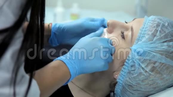 在美容院医生和美容师为女孩做隆唇手术的准备视频的预览图