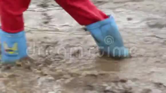 穿胶靴走路的小孩脚泥泞工地视频的预览图