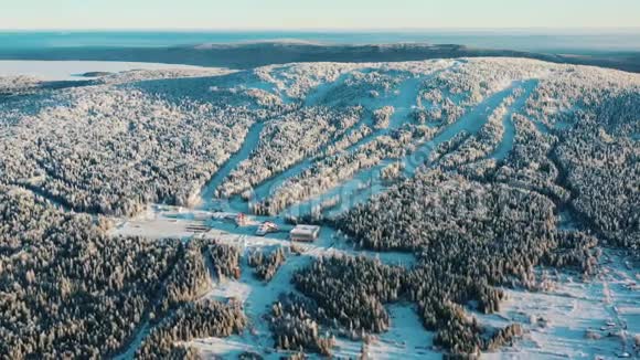 冬季被森林包围的滑雪胜地的鸟瞰图录像户外运动视频的预览图