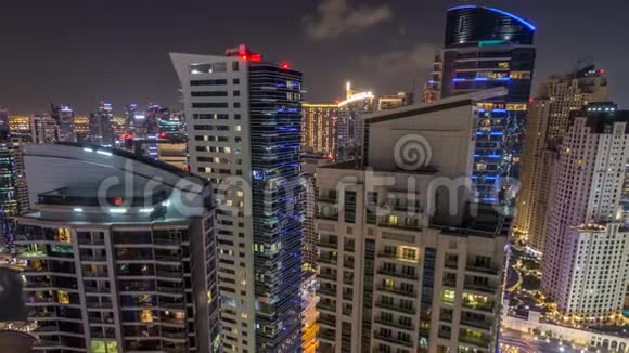 在迪拜Jumeirah海滩住宅JBR和迪拜码头夜间时间推移的现代照明摩天大楼的鸟瞰图视频的预览图