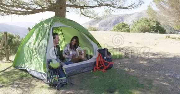 知足的夫妇坐在树下的帐篷里视频的预览图