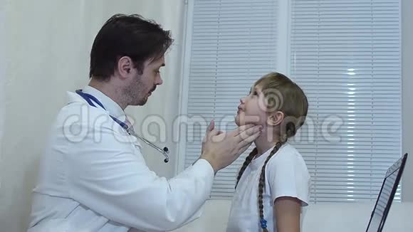 儿童医生在办公室里看孩子的喉咙医生在办公室里检查女孩视频的预览图