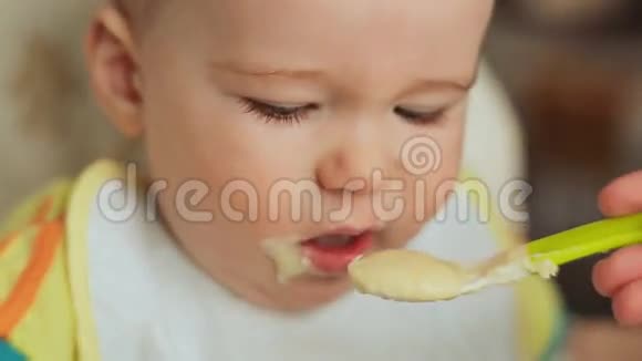 母亲喂养她反复无常的孩子给他粥和果汁面对特写镜头视频的预览图