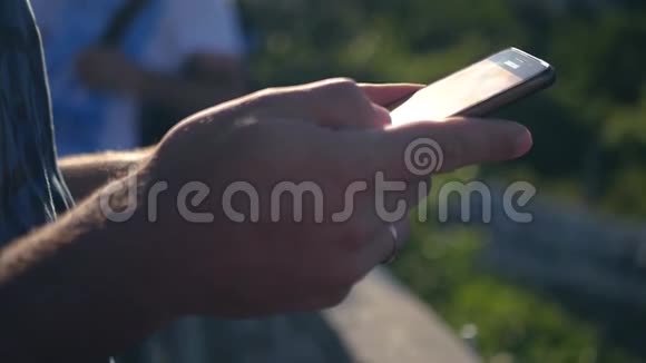 一个男人手里拿着一部手机手机捕捉到阳光闪进相机高清1920x1080视频的预览图