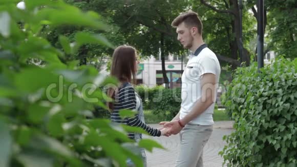 一对情侣在公园里牵手交谈视频的预览图