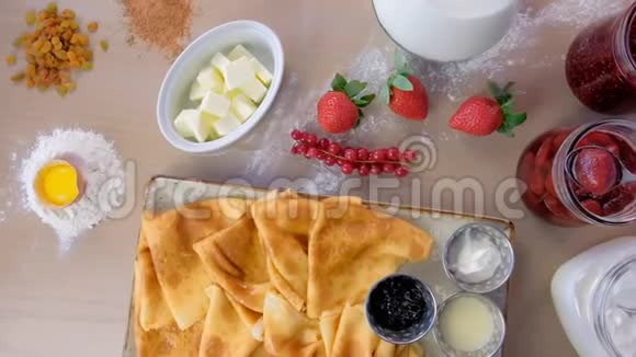 俄罗斯传统煎饼布里尼提供果酱酸奶油和草莓盘特写俯视图视频的预览图