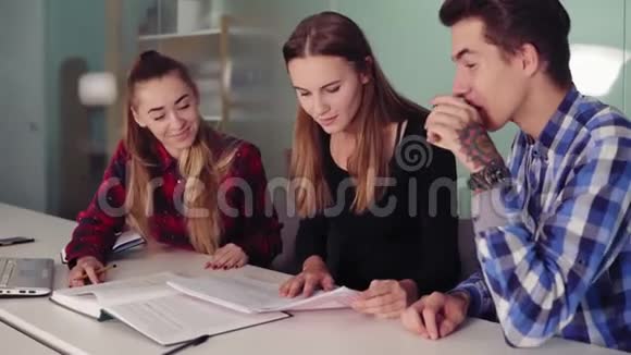 快乐的学生一起做作业坐在桌子旁喝咖啡青年群体视频的预览图