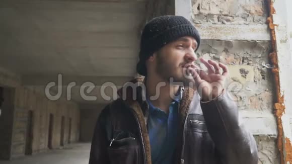 无家可归的人在废弃的大楼里抽烟视频的预览图