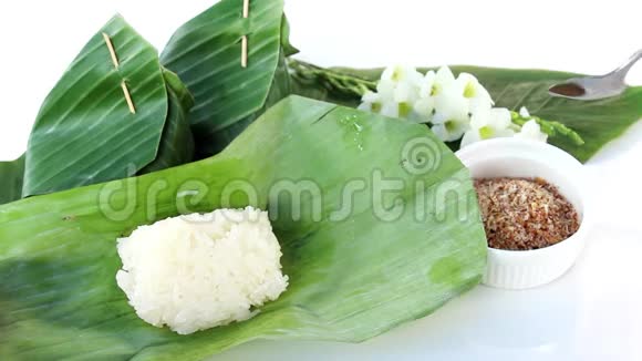 泰国甜点糯米与干鱼顶部包裹香蕉叶在白色背景视频的预览图