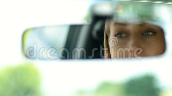 可爱的女人在汽车后视镜里涂睫毛膏视频的预览图