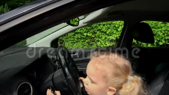 儿童假装驾驶汽车坐在驾驶座前双手操纵视频的预览图