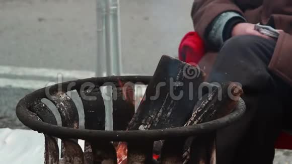 冻人取暖明火垃圾箱火木燃烧视频的预览图