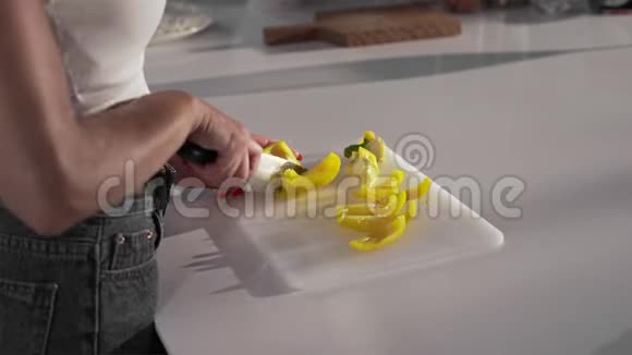 女人用锋利的刀切黄椒女人在厨房做菜做菜视频的预览图
