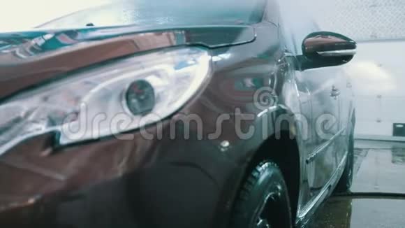 在汽车修理车间洗一辆车用水管清洗肥皂视频的预览图