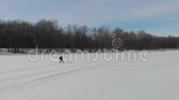 鸟瞰一位老年妇女在冬季森林里用棍子从事北欧行走健康生活方式视频的预览图