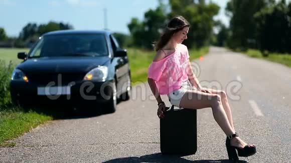 可爱的女人坐在乡村路上的罐子里视频的预览图
