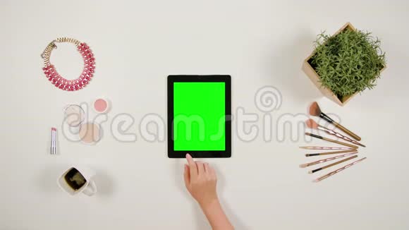 女士的手指在绿色触摸屏上滚动视频的预览图