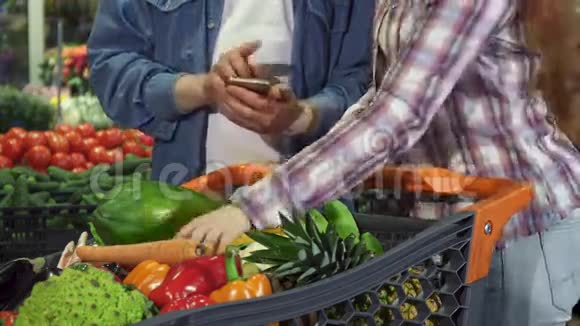 几个人在购物车里分类蔬菜和水果视频的预览图