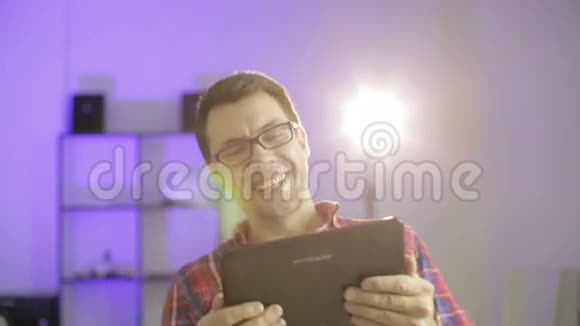开朗的男人拿着平板电脑微笑着视频的预览图