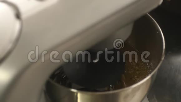 一个人打开搅拌机准备蛋糕的慢速镜头视频的预览图