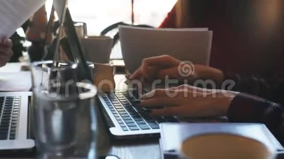 两个女商人在咖啡馆里用笔记本电脑打字视频的预览图