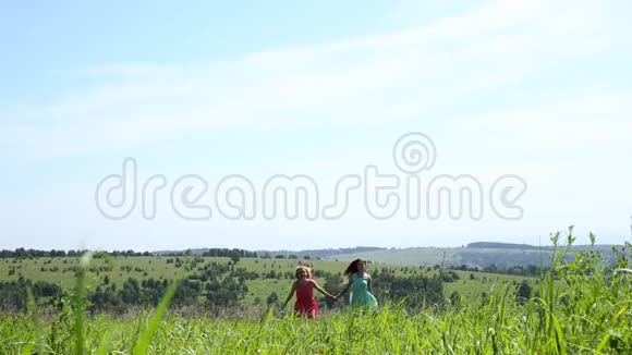 两个年轻的女孩手牵着手在田野上奔跑自由和关系视频的预览图