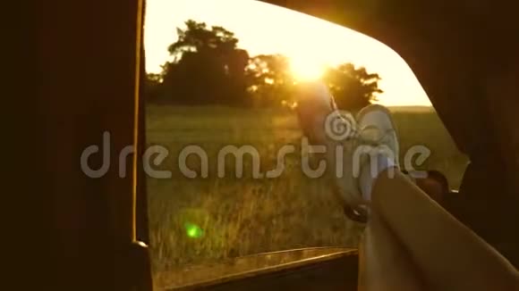 女人开车旅行年轻的女人喜欢坐汽车旅行把腿从敞开的窗户里伸出来一个女孩的腿视频的预览图