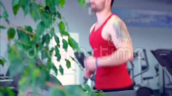 男子在运动健身房的跑步机上锻炼和跑步视频的预览图
