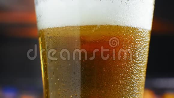 特写慢镜头冷啤在一个杯子里大滴和气泡在啤酒里视频的预览图