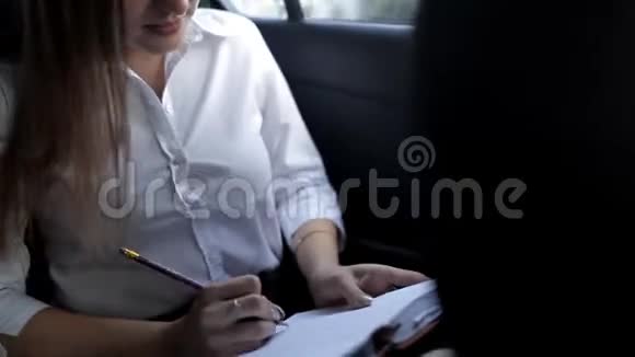 年轻女孩坐着出租车正在为商务会议做准备在记事本上做笔记视频的预览图