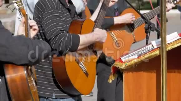 街头音乐家乐队演奏的声学吉他慢动作视频的预览图