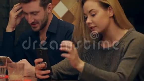 一对年轻夫妇用手机和芬妮自拍照片坐在咖啡馆里视频的预览图