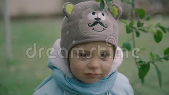 特写可爱的幼儿男孩穿着冬衣围巾和帽子雪花的肖像慢镜头录像4k视频的预览图