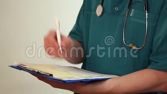 医生在剪贴板上做笔记填写医疗表格报告视频的预览图