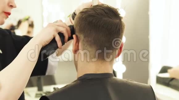 理发师用剪发器剪下男性头发并在美发沙龙近距离梳理美容师在做视频的预览图