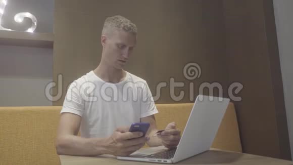 男人用信用卡和智能手机付款视频的预览图