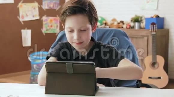 可爱的小男孩用数码平板电脑浏览互联网视频的预览图