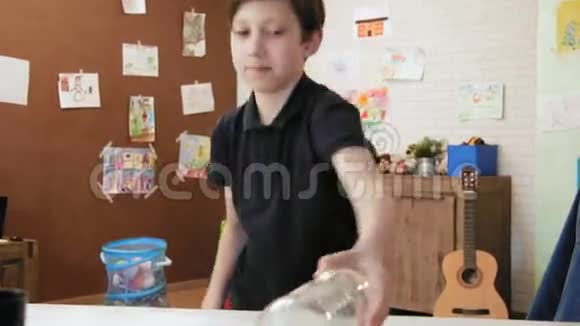 可爱的小男孩在他的房间里玩水瓶翻转挑战视频的预览图