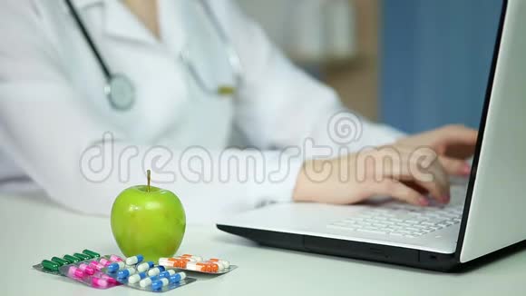 医生在办公室用笔记本电脑吃苹果健康饮食适当营养视频的预览图