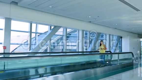 站在自动人行道上的女人站在地铁口的楼梯上用她的电话一种交流的手段一种时尚视频的预览图